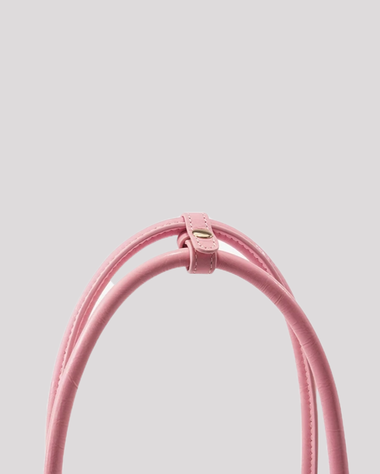 Close-up of pink leather shoulder bag by Bafelli handles with stitched strap holder