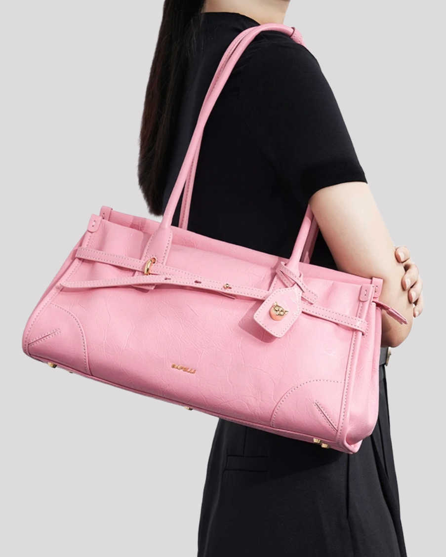 Woman carrying pink leather shoulder bag by Bafelli over shoulder – lifestyle view