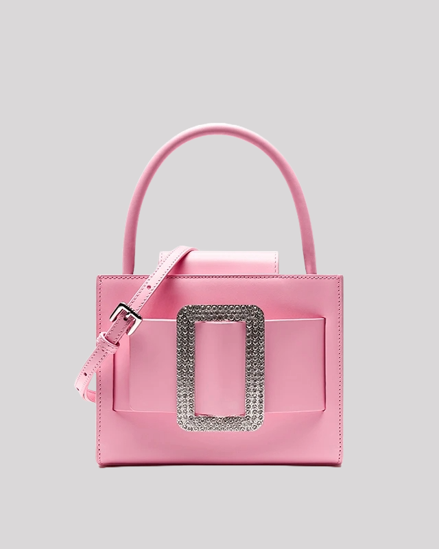 Front view of pink top-handle bag by Bafelli with oversized rhinestone buckle and detachable shoulder strap