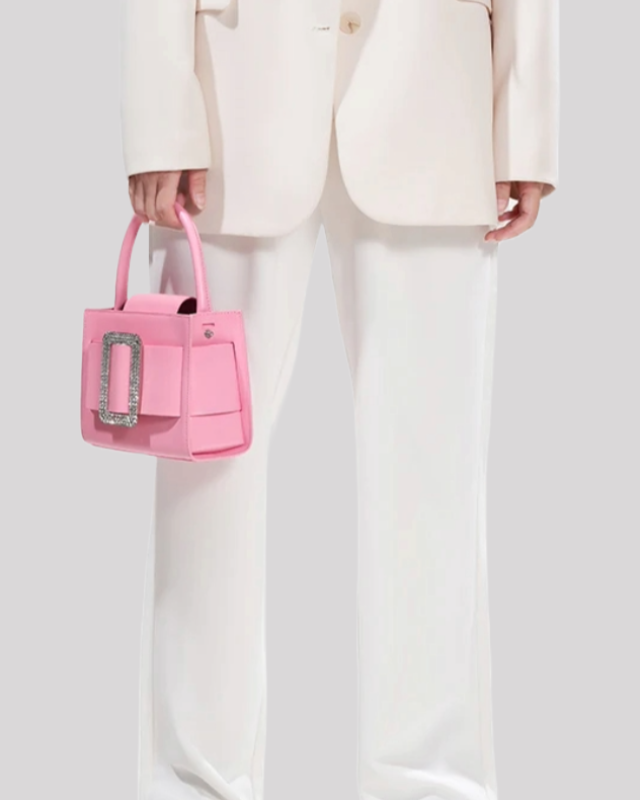Pink top-handle bag by Bafelli carried by hand, styled with elegant outfit