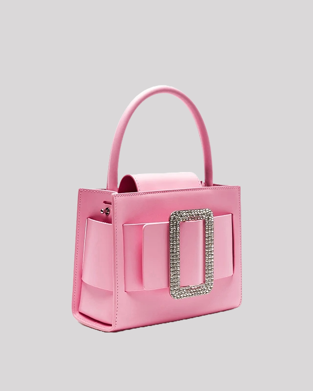 Side view of pink top-handle bag by Bafelli with sparkling buckle and structured shape