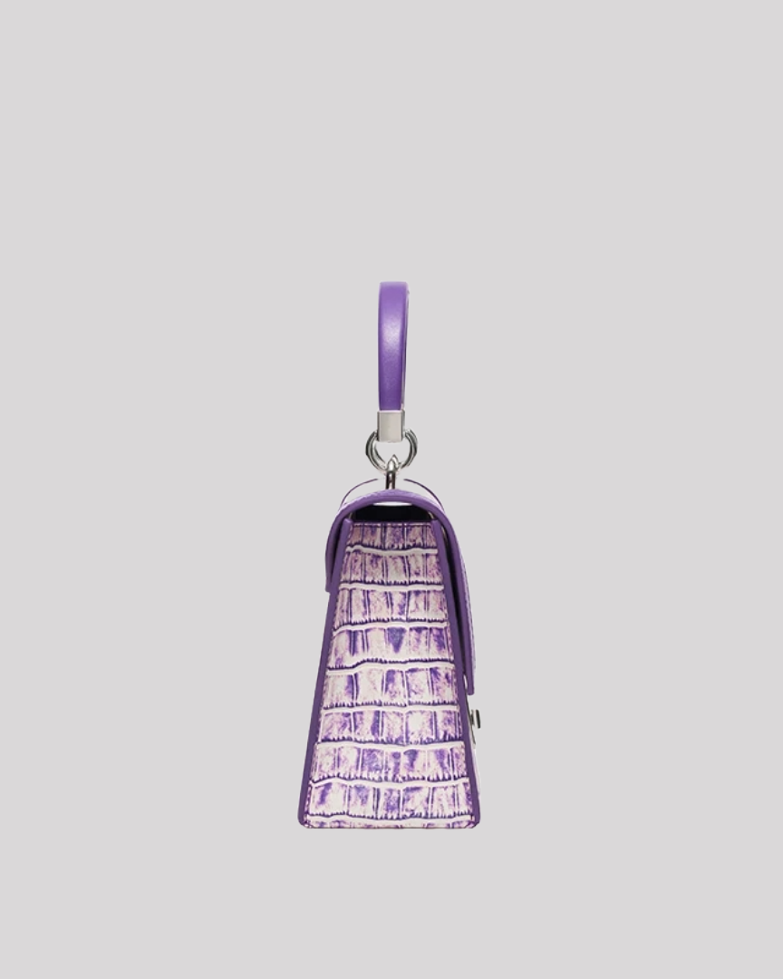 Side profile of purple croc-embossed structured handbag by Bafelli with trapeze silhouette