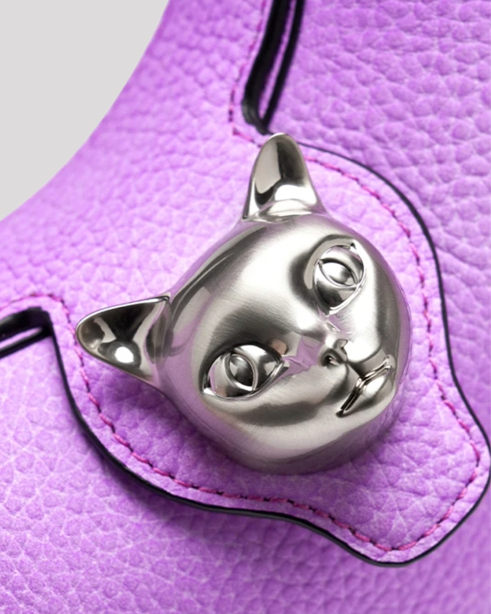 Close-up of silver cat clasp on purple leather hobo bag by Bafelli with textured leather