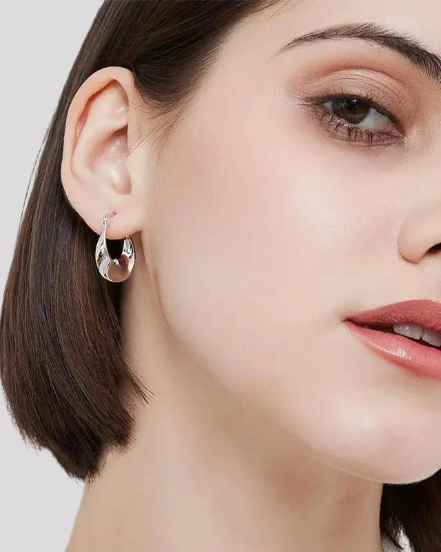 Woman wearing silver wavy hoop earrings – elegant styling