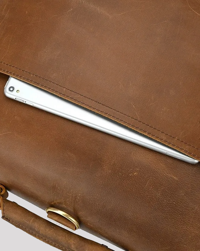 Bottom of vintage mocha leather messenger bag with metal hardware