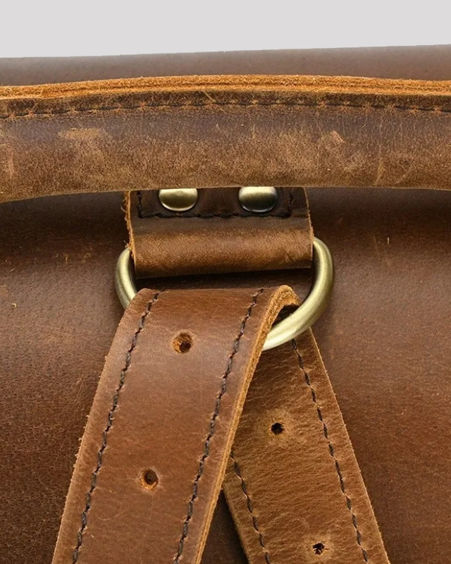 Front view of vintage mocha leather messenger bag with closed buckle straps
