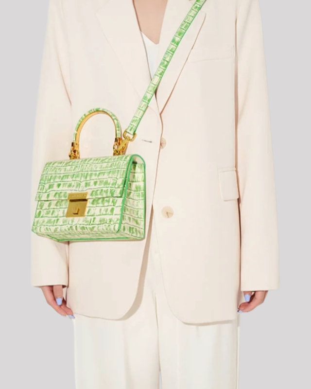 White and green croc-embossed top handle bag by Bafelli worn crossbody with matching strap and gold closure
