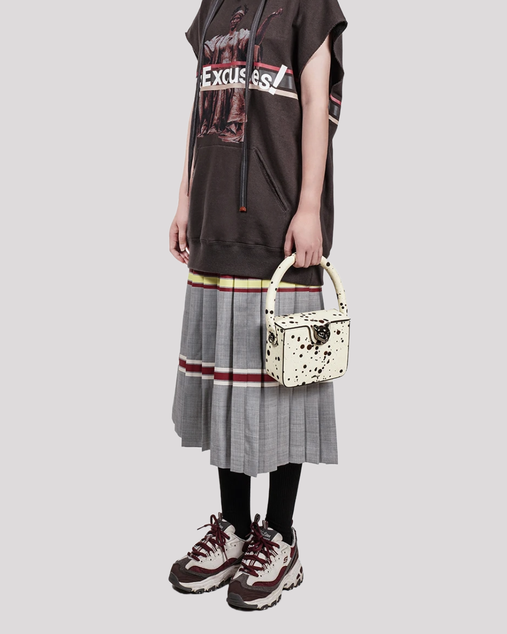 Woman holding white speckled box bag by Bafelli with round handle – styled with casual streetwear outfit