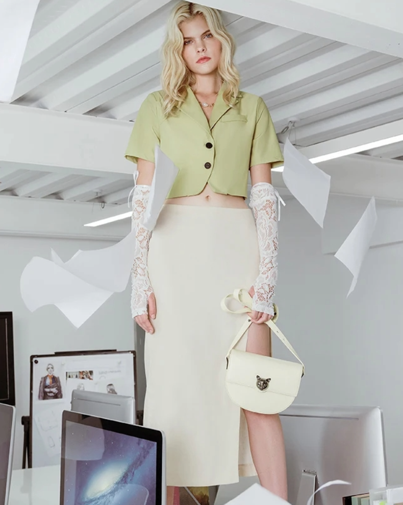 Women’s white leather crossbody bag by Bafelli – elegant handbag with cat head clasp, styled by model in outfit