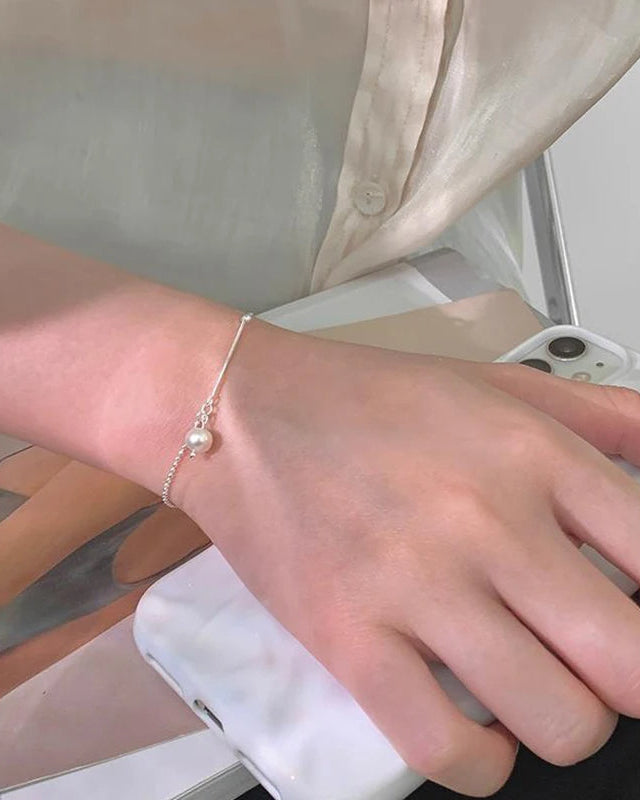 Modern women’s silver bracelet with pearl pendant – elegant accessory styled with everyday outfit